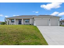 Charming single-story home with a well-manicured lawn and a spacious two-car garage on a sunny day at 10493 Grail Ave, Englewood, FL 34224