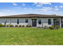Charming one-story home with a well manicured lawn, tiled roof, and lush landscaping at 10816 Wendover Dr, Palmetto, FL 34221