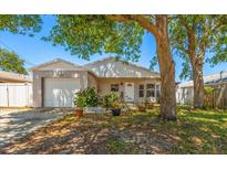 Charming single-story home featuring a well-manicured lawn, mature trees, and an attached one-car garage at 1108 16Th Nw Ave, Clearwater, FL 33756