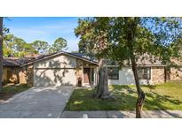 Charming single-story home with stone accents, a well-maintained lawn, and mature trees providing shade at 15118 Brushwood Dr, Tampa, FL 33624