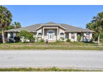 Spacious single-story home with a manicured lawn and mature trees, offering great curb appeal at 284 Peninsula Ave, Tarpon Springs, FL 34689