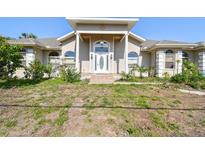 Charming single-Gathering home with front yard, columns, arched windows, and a decorative glass front door at 284 Peninsula Ave, Tarpon Springs, FL 34689