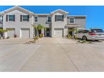 Inviting townhomes featuring a clean gray exterior, one-car garage and tidy landscaping at 33105 Major Oak Dr, Wesley Chapel, FL 33545