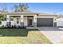 Beautiful single Gathering home featuring a two car garage, stone accents, and a covered front porch at 3326 W Heiter St, Tampa, FL 33607
