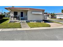 Charming single-story home with a cozy front porch and well-maintained lawn at 34461 Cactus Dr, Pinellas Park, FL 33781