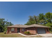 Charming single-story brick home featuring a well-maintained yard and attached garage at 35109 Excalibur, Webster, FL 33597