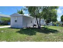 View of a manufactured home, showcasing its siding and surrounding fenced yard at 5830 Portsmouth Dr, Tampa, FL 33615