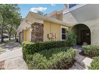 Well-kept townhome exterior with stone accents and lush green bushes at 8125 Stone Path Way, Tampa, FL 33647