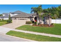 Well maintained single-Gathering home featuring a three car garage, tidy landscaping, and curb appeal at 8628 Eagle Brook Dr, Land O Lakes, FL 34638
