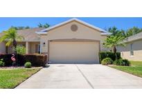 Charming single-story home with a two-car garage, manicured landscaping, and mature palm trees at 1023 Orca Ct, Holiday, FL 34691