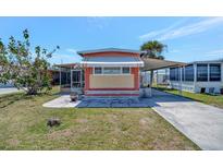 Charming home featuring vibrant exterior, awning, carport, and well-maintained lawn at 104 Saint Kitts Way, Apollo Beach, FL 33572