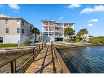 Waterfront condo featuring a private dock and multiple balconies with stunning water views on a clear, sunny day at 19817 Gulf Blvd # 602, Indian Shores, FL 33785