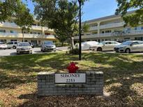 Three-story building facade with several parked cars in front, trees and a red fire hydrant with signage at 2253 Norwegian Dr # 63, Clearwater, FL 33763