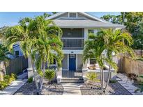 Charming two-story home features a blue door, an upstairs balcony, and tropical landscaping at 2635 13Th N Ave, St Petersburg, FL 33713