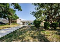 Charming single-story home with a covered carport and mature trees in the front yard at 3216 W Paxton Ave, Tampa, FL 33611