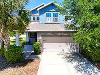 Charming blue two-story home with manicured landscaping and a spacious two-car garage at 7502 Sea Lilly Ct, Apollo Beach, FL 33572