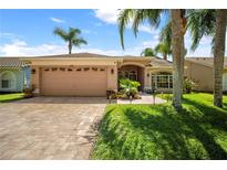 Charming single-story home with a paved driveway, well-manicured lawn, and a two-car garage at 12918 Royal George Ave, Odessa, FL 33556