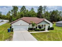 Charming single-story home with a well-manicured lawn, two-car garage and inviting front porch at 13486 English Sparrow Rd, Weeki Wachee, FL 34614