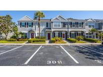 Well-maintained townhome exterior featuring neat landscaping, reserved parking, and classic architectural details at 309 Countryside Key Blvd, Oldsmar, FL 34677