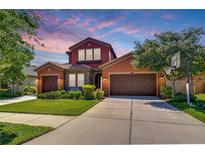 Charming two-story home featuring an attached two-car garage and a manicured lawn at 4289 Ortona Ln, Wesley Chapel, FL 33543