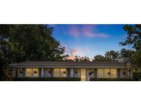 Charming home exterior featuring a well-maintained yard, hanging flower baskets, and a welcoming facade at dusk at 4340 Narvarez S Way, St Petersburg, FL 33712