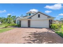 Charming home with a brick driveway, three-car garage, and well-maintained landscaping at 5518 72Nd E Ter, Ellenton, FL 34222