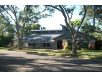 Beautifully landscaped home with a modern roof design and mature trees at 7033 123Rd St, Seminole, FL 33772