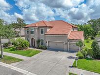 Beautiful two-story home boasts lush landscaping, a tile roof, and a spacious three-car garage at 7927 Hampton Lake Dr, Tampa, FL 33647