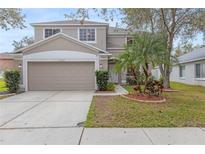 Charming two-story home boasts a well-manicured lawn, a two-car garage, and complemented by lush tropical landscaping at 10525 Lucaya Dr, Tampa, FL 33647