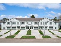Charming multi-Gathering home featuring a row of townhouses with individual garages and landscaped front yards at 11718 Blackbrook Ct, Seffner, FL 33584