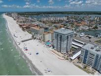 Stunning aerial view of beachfront condo complex and beautiful coastline, near pristine sandy beach on a sunny day at 17408 Gulf Blvd # 1302, Redington Shores, FL 33708