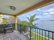 Enjoy scenic water views and outdoor grilling on this private balcony with a gas grill and black metal railing at 2675 St Josephs E Dr # C, Dunedin, FL 34698
