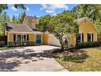Charming yellow home with a well-maintained lawn and driveway at 305 Bryan Oak Ave, Brandon, FL 33511
