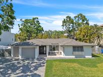 Charming single story home featuring manicured lawn, modern design, and brick paved driveway, with a covered front porch at 349 Belleair Ne Dr, St Petersburg, FL 33704