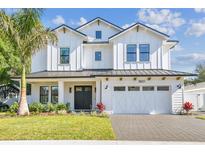 Stunning two-story white farmhouse with a black metal roof and an attached two car garage at 3821 W Vasconia St, Tampa, FL 33629