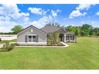 Charming single-story home featuring a lush green lawn and a well-maintained landscape at 41043 Stanton Hall Dr, Dade City, FL 33525