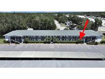 Spacious condo building featuring ample parking, lush landscaping, and convenient access to nearby amenities at 100 Glennes Ln # 108, Dunedin, FL 34698