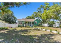 Charming green home with a white picket fence and a well-manicured front yard at 1046 Yale N St, St Petersburg, FL 33713