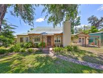 Charming stone home with a metal roof and lush front yard landscaping at 10824 Palmetto St, Riverview, FL 33569