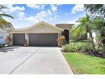 Charming home featuring a three-car garage, well-maintained landscaping, and a concrete driveway at 16118 Lytham Dr, Odessa, FL 33556