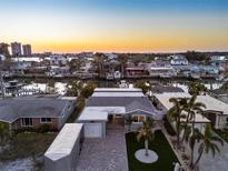Beautiful waterfront home with lush landscaping, private boat dock and a stunning sunset view at 17730 Long Point Dr, Redington Shores, FL 33708