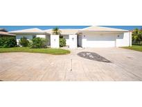 Charming single-story home with a two-car garage, lush landscaping, and an inviting walkway to the front door at 2015 Hawaii Ne Ave, St Petersburg, FL 33703