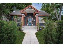 Charming home featuring a blue door, copper accents, and a well-manicured walkway and landscaping at 2536 Burlington N Ave, St Petersburg, FL 33713