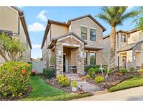 Charming two-story home featuring a stone-accented porch and a well-maintained lawn with lush landscaping at 28638 Tranquil Lake Cir, Wesley Chapel, FL 33543