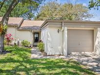 Charming single-story home featuring an attached garage and well-manicured lawn, presenting curb appeal at 3203 Green Dolphin St, Tarpon Springs, FL 34689