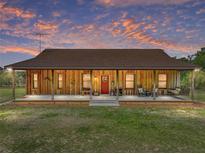 Charming single-story home with a full-length porch and inviting red front door at 35657 Ashley Ln, Dade City, FL 33523