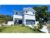 Contemporary two-story home featuring stucco siding, a blue garage door, and minimal landscaping at 3605 W Anderson Ave, Tampa, FL 33611