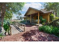 Charming log cabin home with inviting front porch and lush landscaping at 4801 Lynn Oaks Cir, Dover, FL 33527
