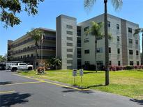 Beautifully landscaped exterior of the Oxford featuring lush green grass and palm trees at 6190 80Th N St # 204, St Petersburg, FL 33709