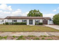 Charming single-story home with a well-manicured lawn, clean design, and a two-car garage at 8721 Bay Crest Ln, Tampa, FL 33615